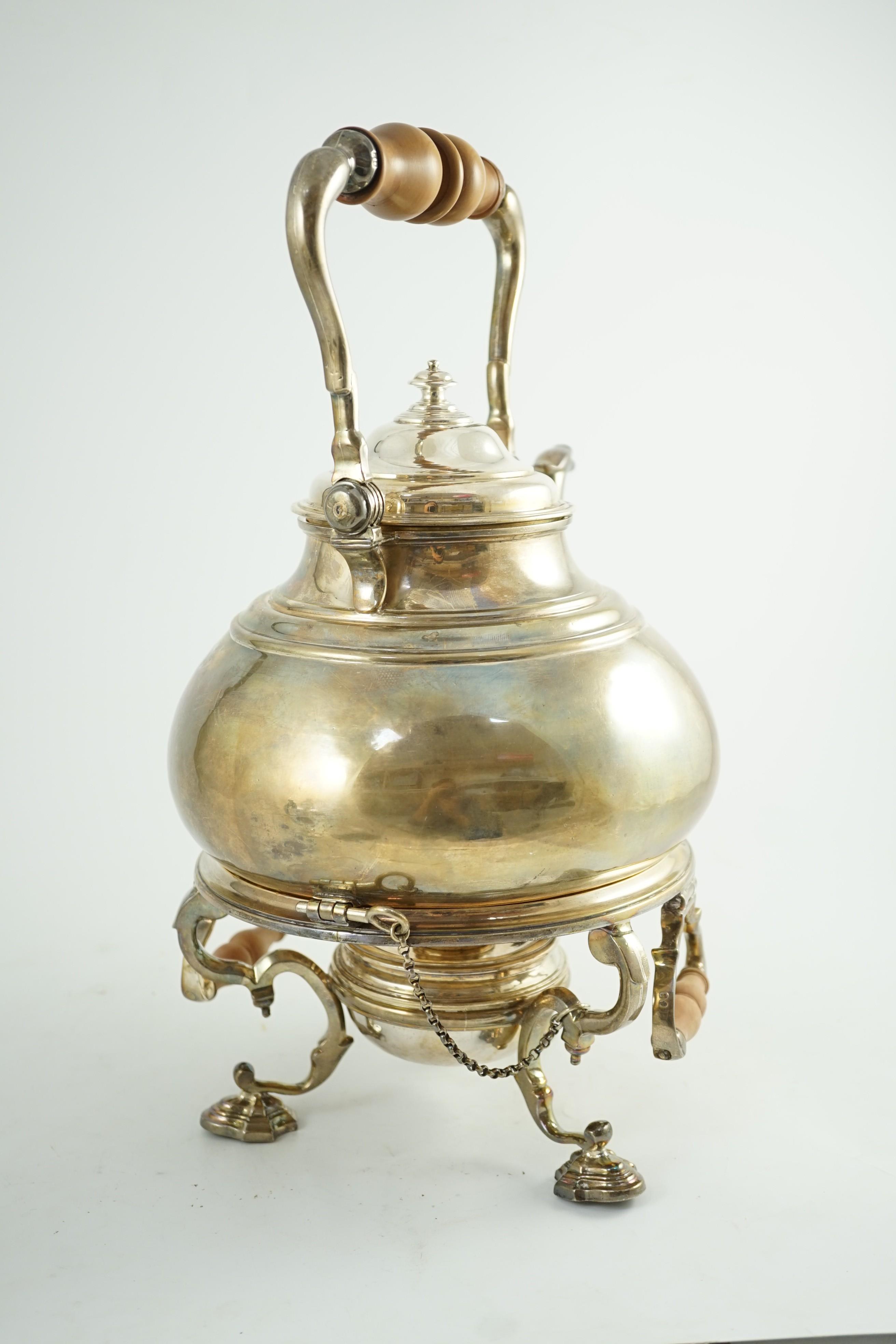 A large George V Britannia standard silver tea kettle on two handled stand, with burner, by Charles & Richard Comyns